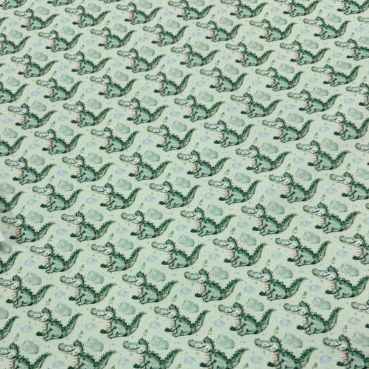 Nature's Fabrics light green fabric with a repeating pattern of cute green crocodiles.