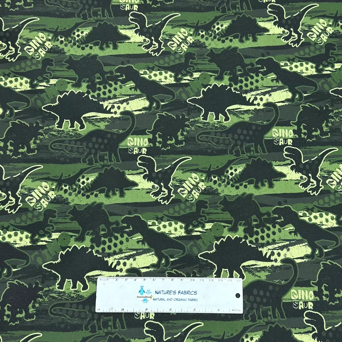 Dinosaur print fabric by Nature's Fabrics — green organic cotton with T-Rex and Stegosaurus silhouettes