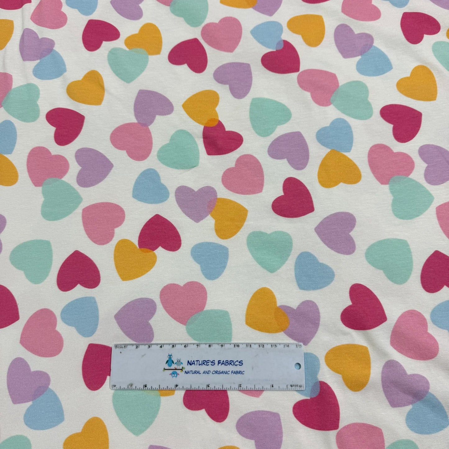 Colorful heart pattern fabric by Nature's Fabrics, organic cotton material with ruler for scale