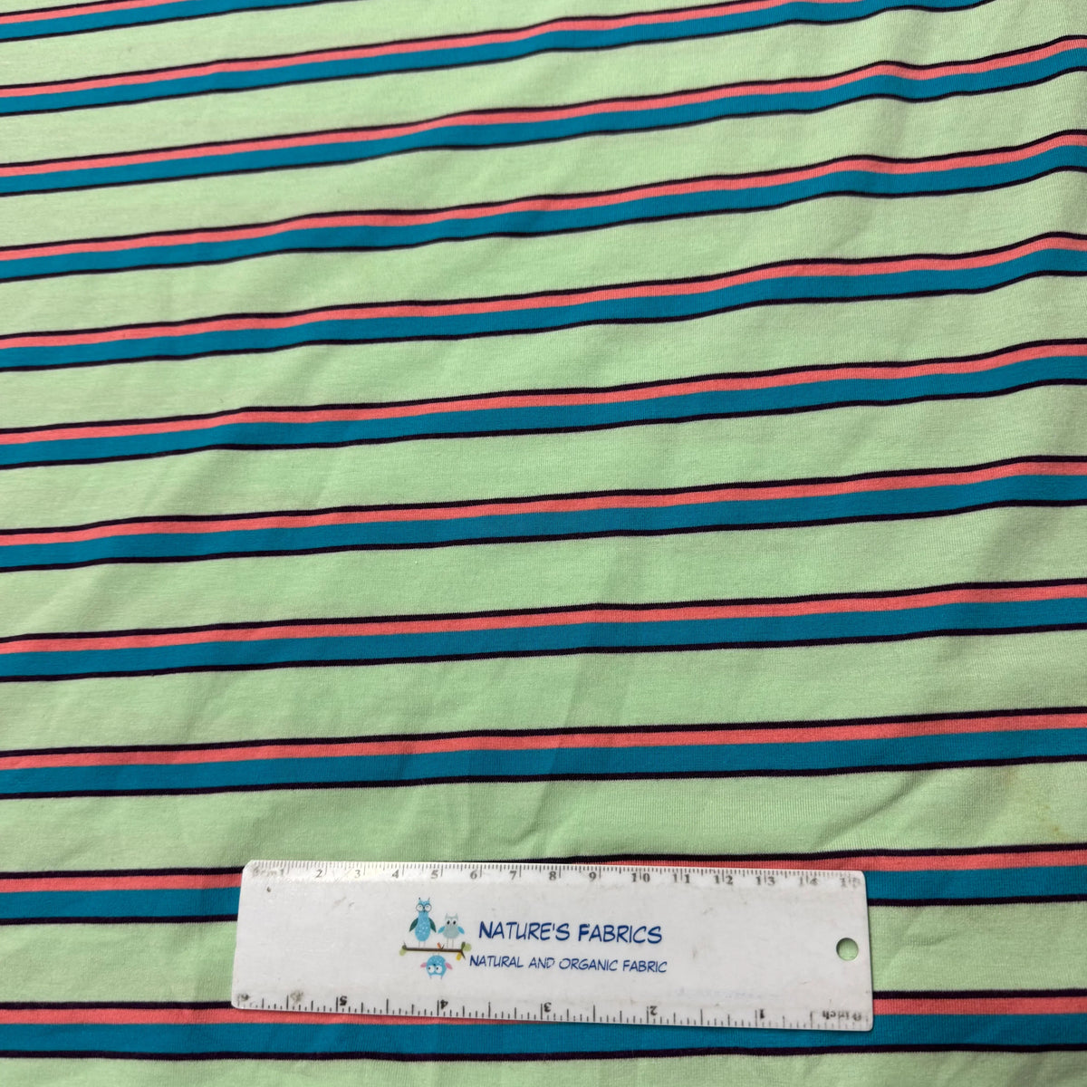 Nature's Fabrics mint green striped organic cotton fabric with ruler for scale, eco-friendly natural textile