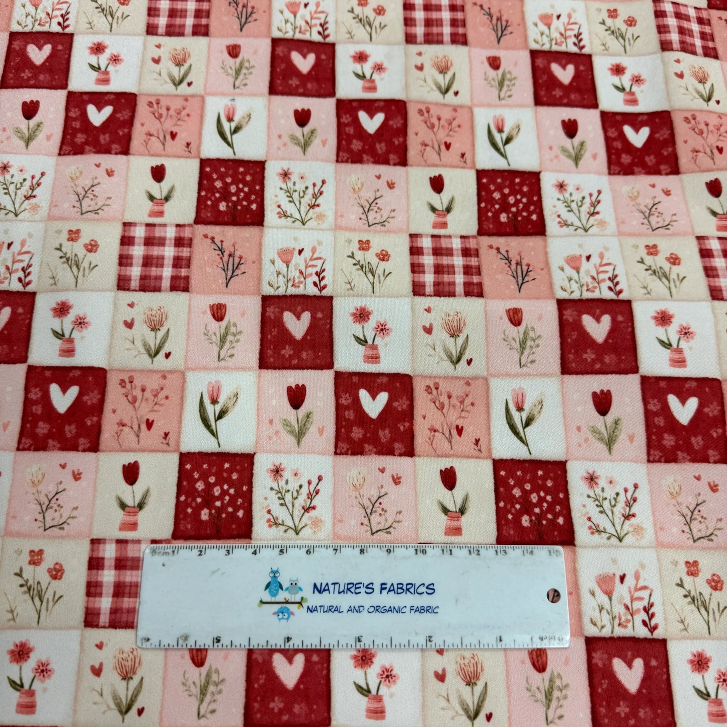 Nature's Fabrics floral patchwork with hearts, tulips, and plaid in red, pink, and cream tones