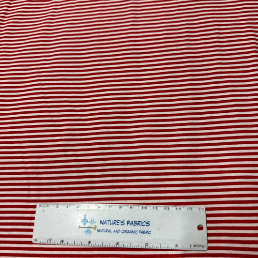 Red and white striped organic cotton fabric by Nature's Fabrics with ruler for scale