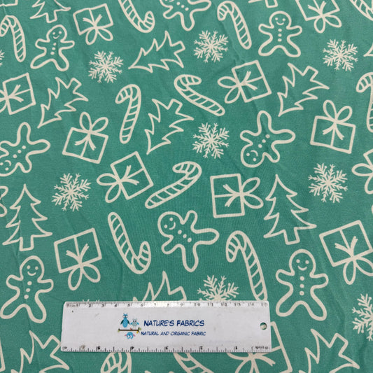 Nature's Fabrics green holiday print with gingerbread, candy canes, snowflakes, and gifts on organic cotton fabric