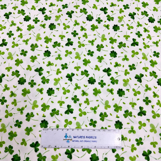 Nature's Fabrics white organic cotton fabric with a green shamrock clover print and ruler.