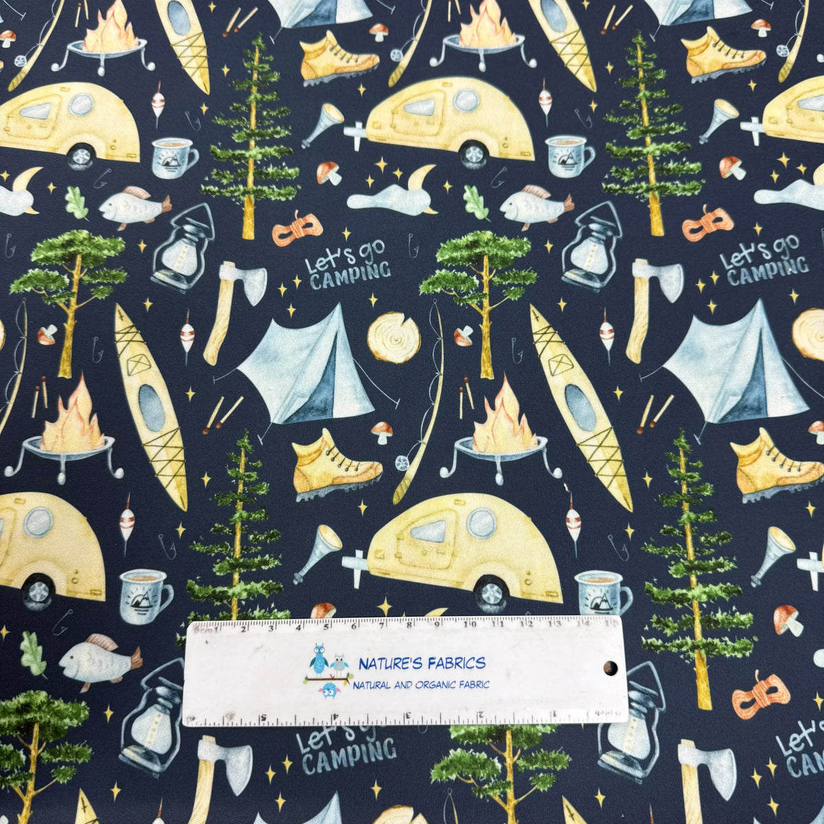 Nature's Fabrics camping-themed print with tents, campfires, trees, and 'Let's Go Camping' text on dark background