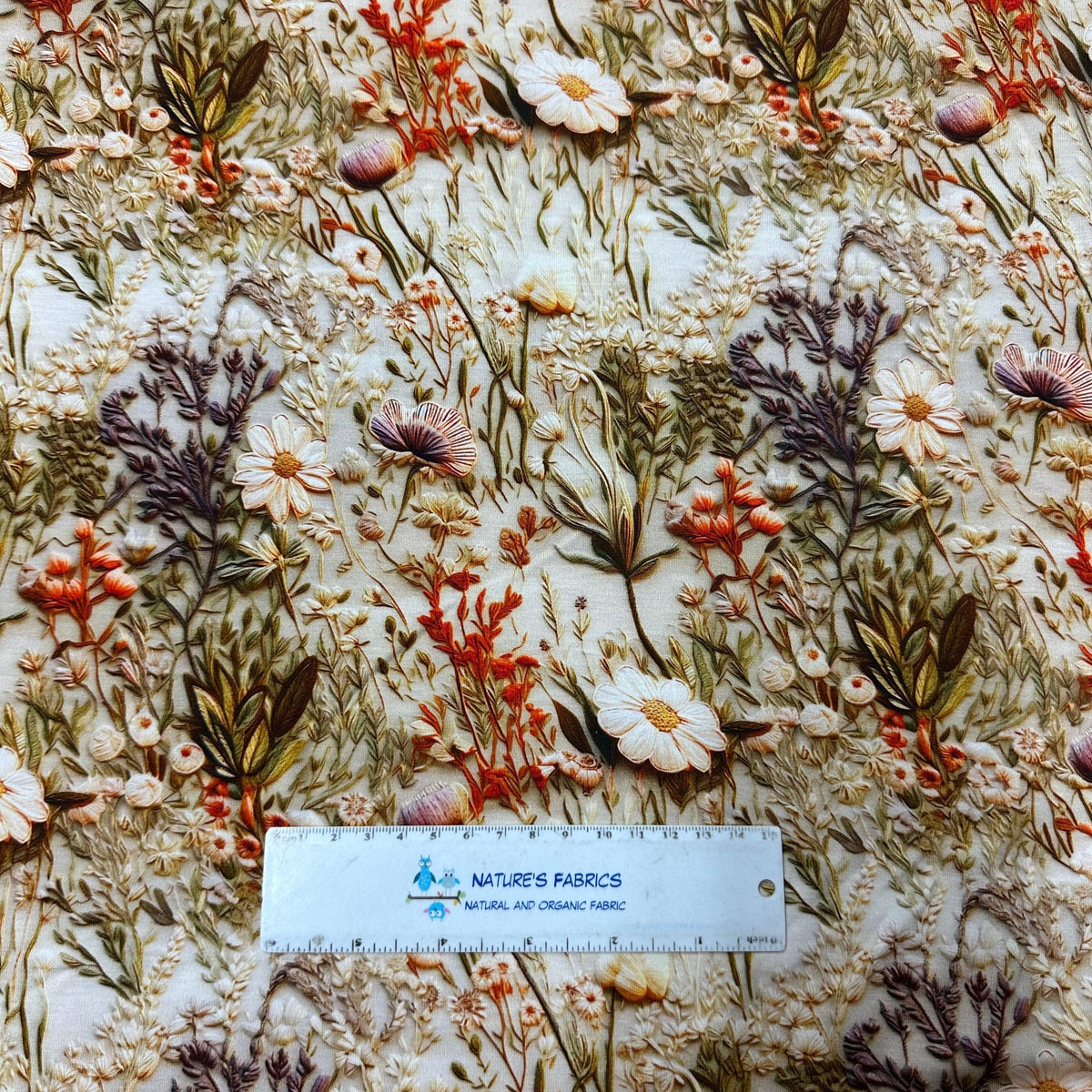 Nature's Fabrics embroidered wildflower pattern on natural fabric with ruler for scale
