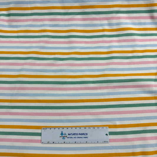 Nature's Fabrics multi-colored striped organic cotton fabric with a ruler for scale.