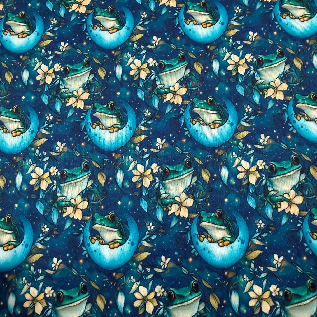 Frog on moon fabric by Nature's Fabrics, featuring green frogs, flowers, and stars on blue background
