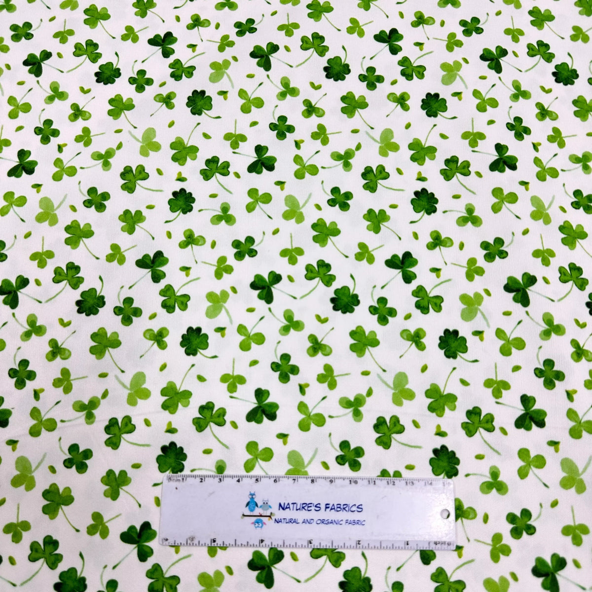 Green shamrock print fabric by Nature's Fabrics, organic cotton material with ruler for scale