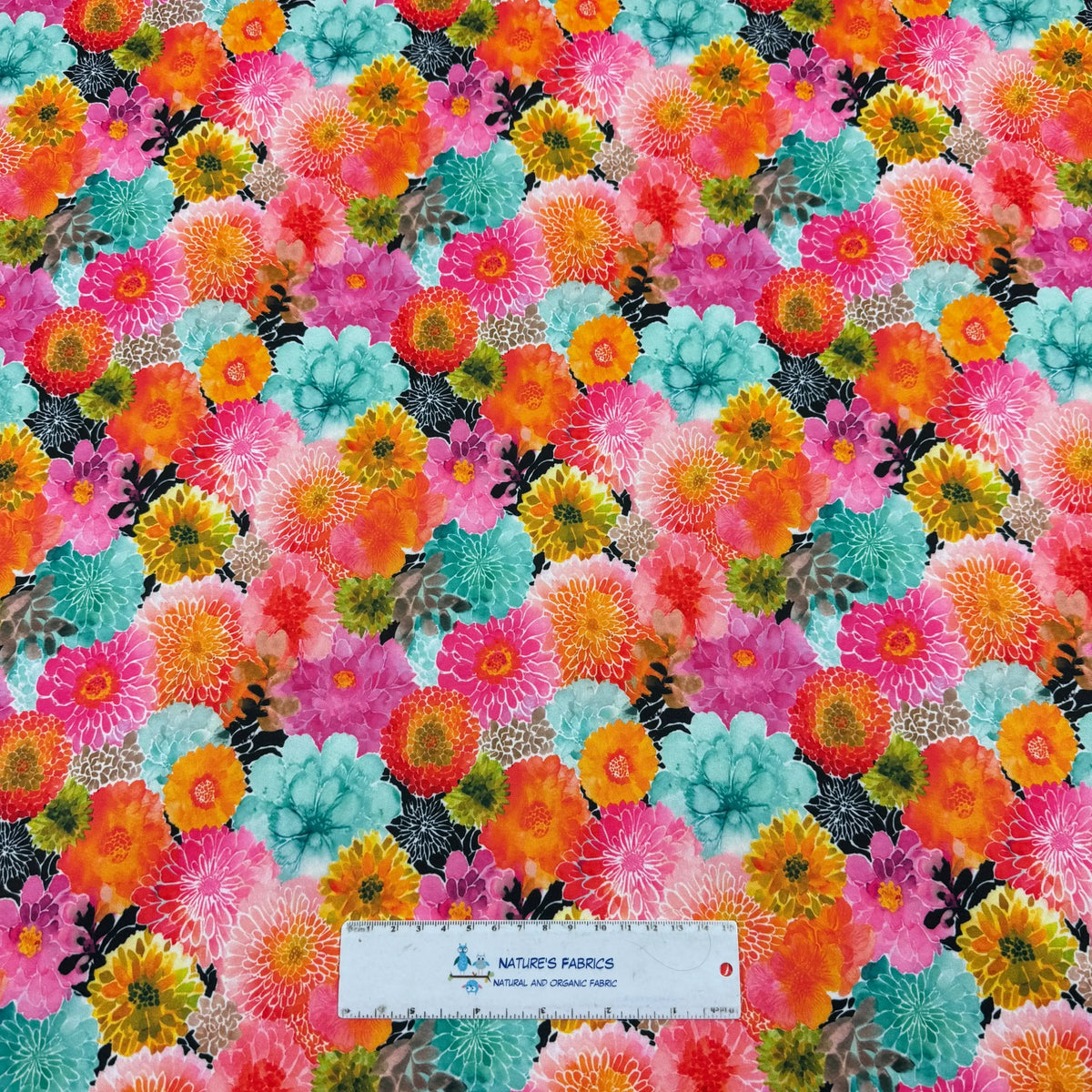 Vibrant floral fabric by Nature's Fabrics, featuring colorful blooms on natural organic cotton.