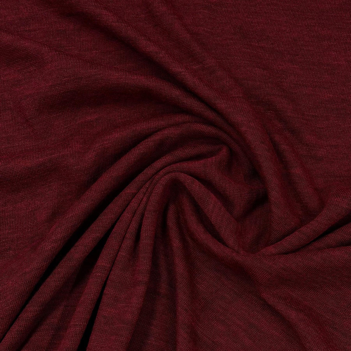 Burgundy colored natural fabric draped in swirls from Nature's Fabrics