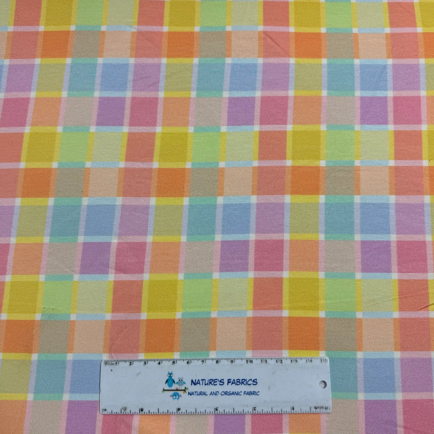 Nature's Fabrics pastel plaid cotton fabric with ruler for scale, showcasing colorful checkered pattern for sewing projects
