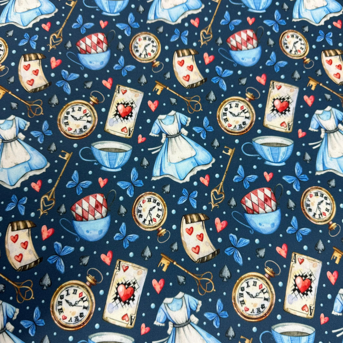 Alice in Wonderland fabric pattern with tea cups, hearts, clocks, and dresses by Nature's Fabrics