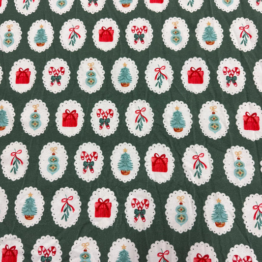 Nature's Fabrics Christmas-themed fabric with trees, gifts, and candy canes on green background