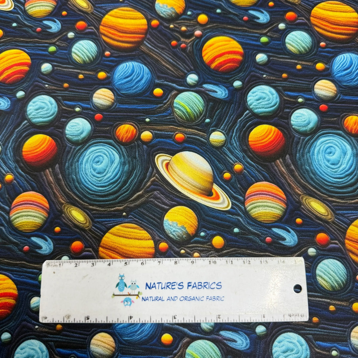 Nature's Fabrics cosmic print fabric with vibrant planets and swirling galaxies, organic cotton by the yard