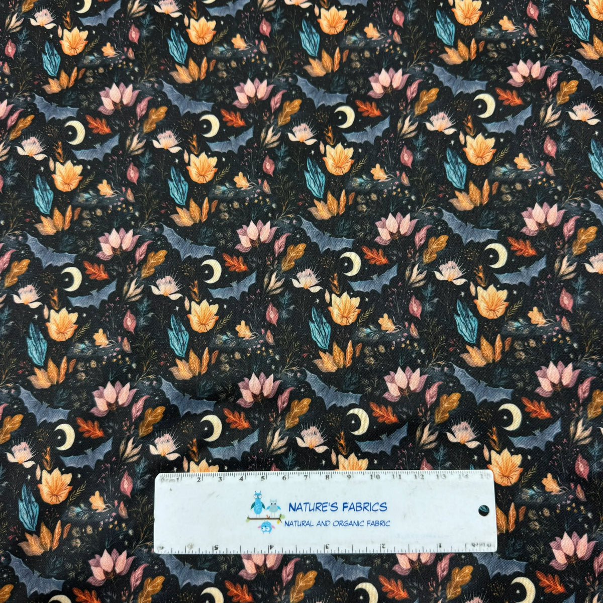 Nature's Fabrics floral pattern with moons and leaves on dark background, organic cotton fabric