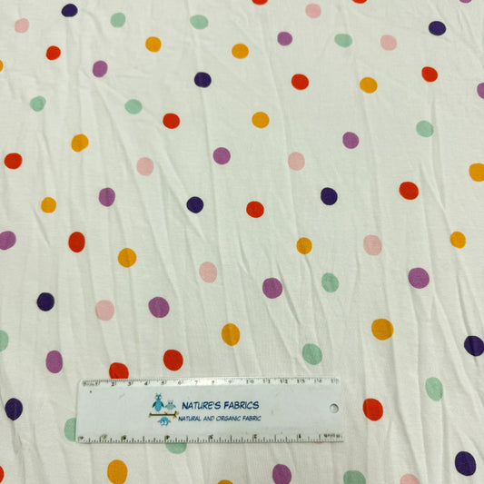 Nature's Fabrics organic cotton fabric with a colorful polka dot print and a ruler for scale.