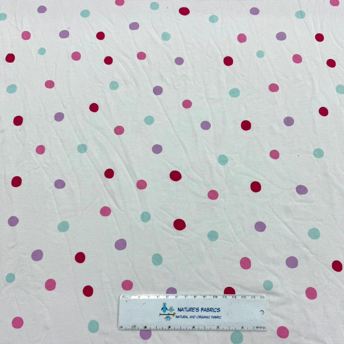 Nature's Fabrics white organic cotton fabric with colorful pastel polka dots.