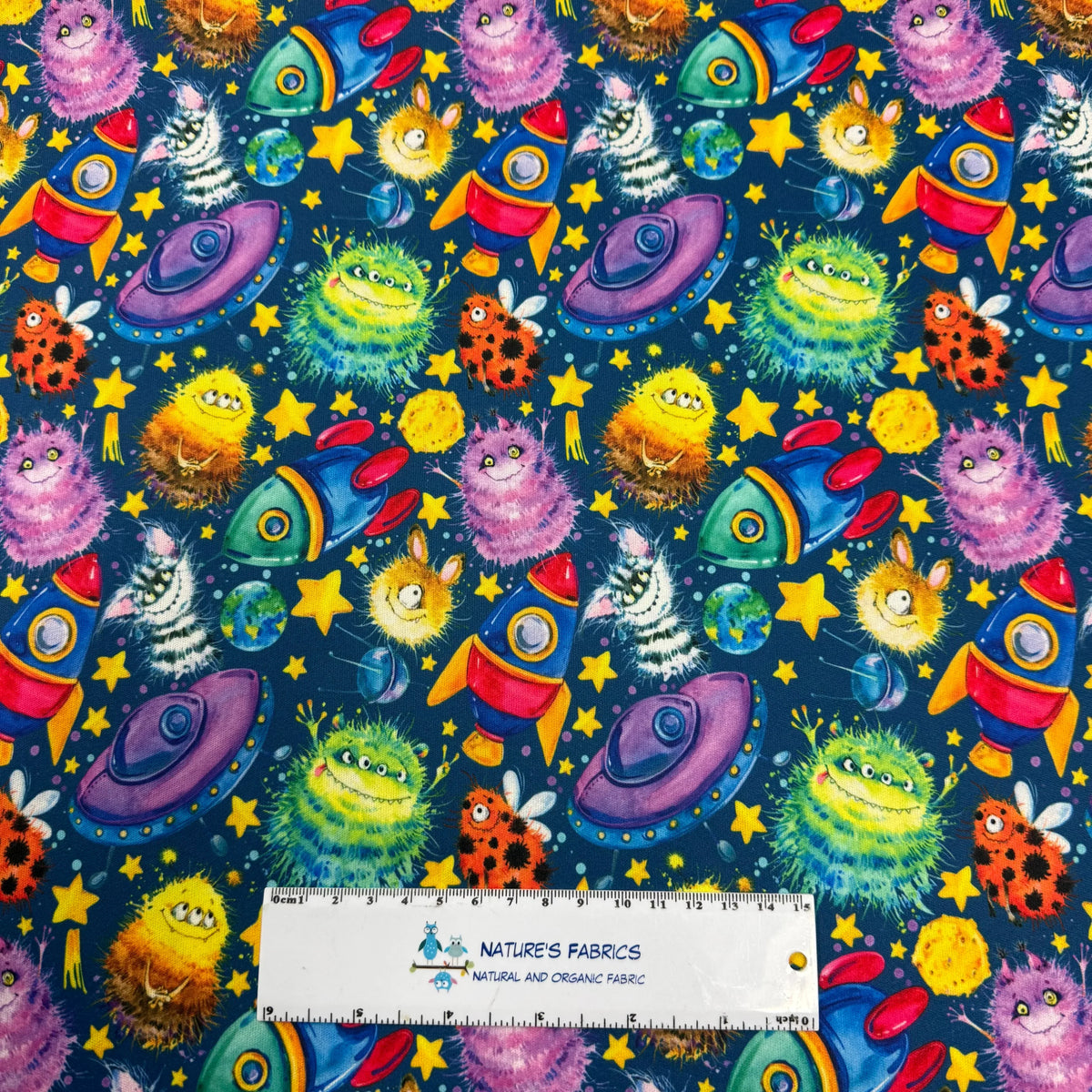 Colorful space-themed fabric with rockets, aliens, stars, and planets by Nature's Fabrics