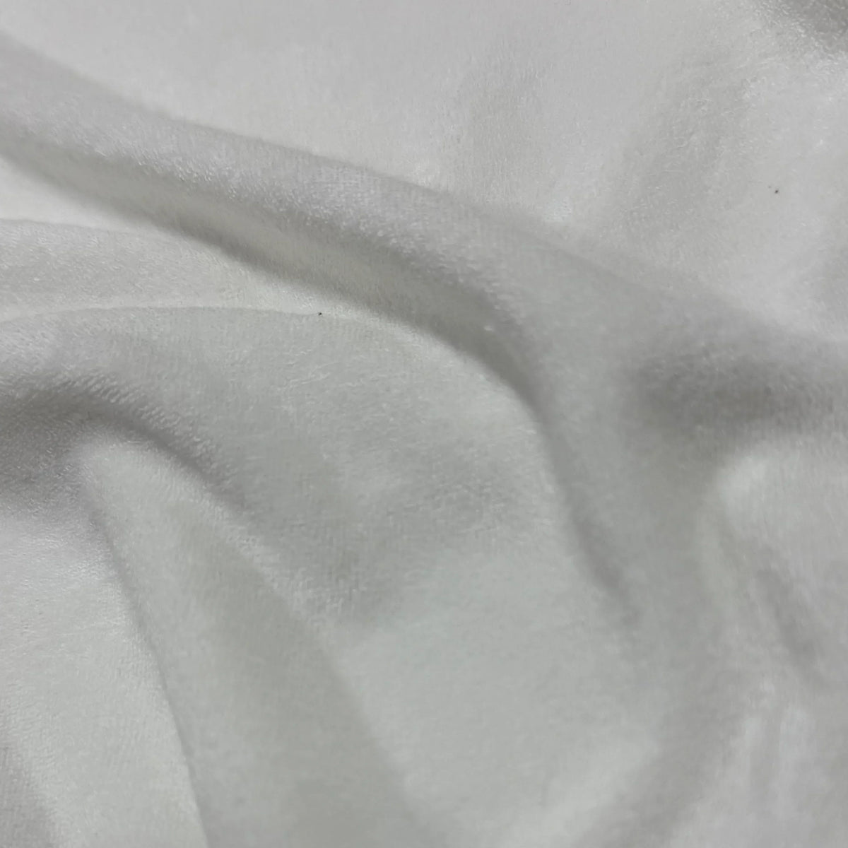 Close-up of white organic cotton fabric with soft, smooth texture and gentle folds