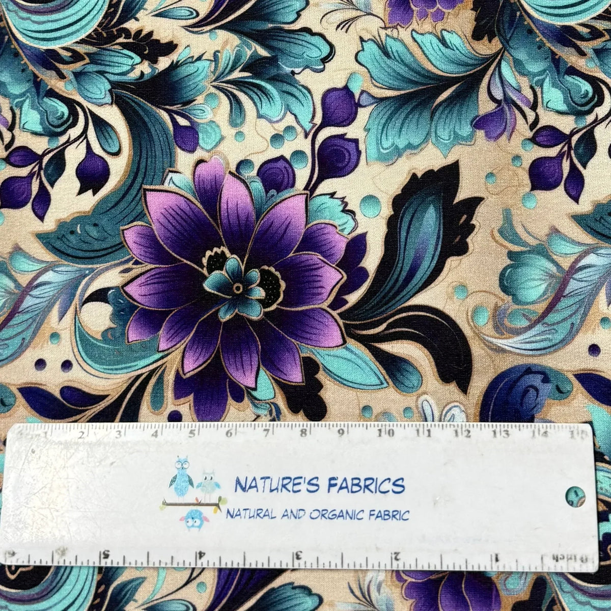 Nature's Fabrics floral pattern fabric in purple, teal, and blue with a ruler for scale.