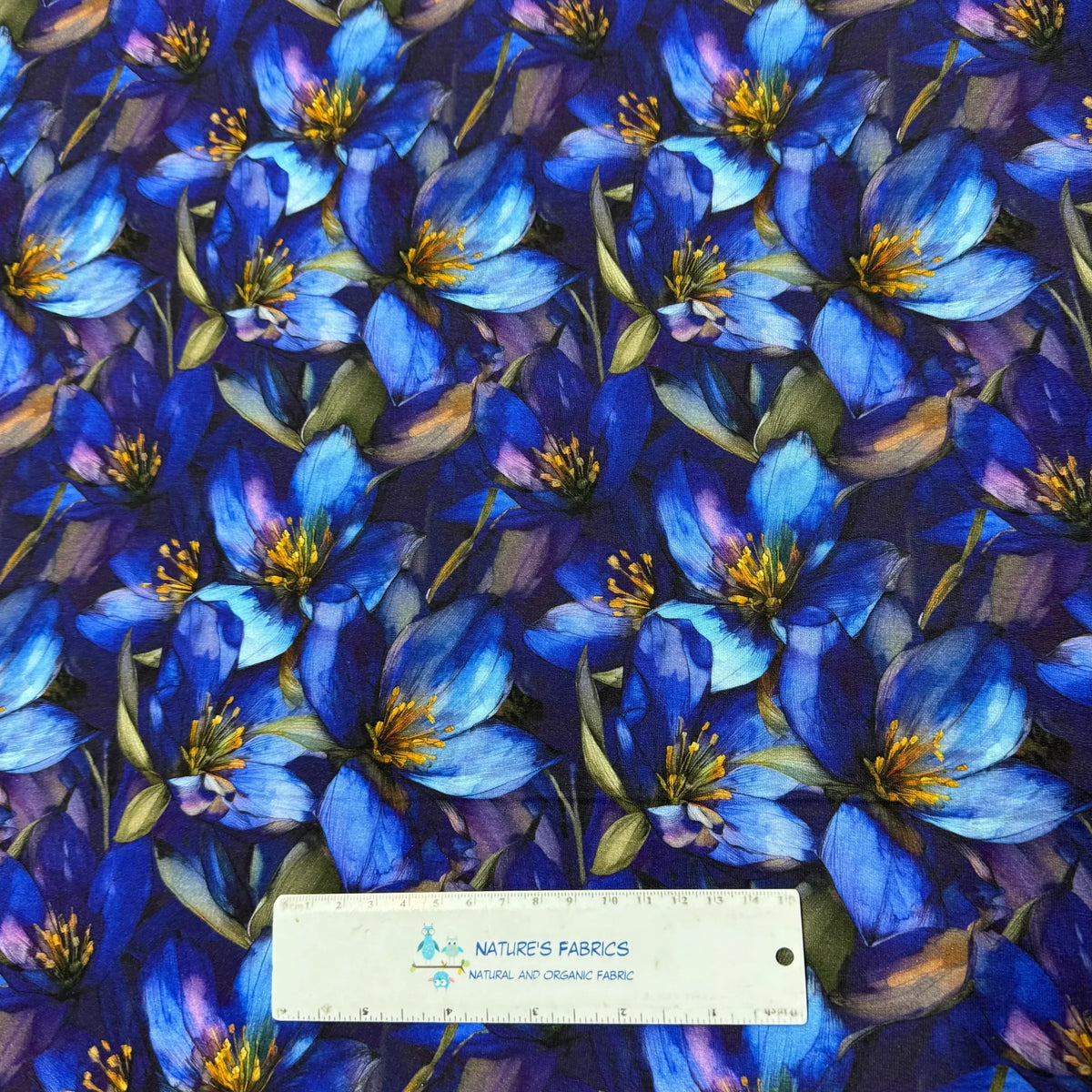 Nature's Fabrics blue floral organic cotton fabric with vibrant blooms and green leaves