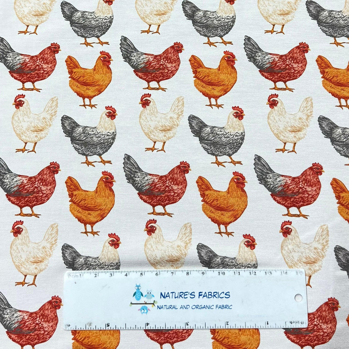 Chicken print organic cotton fabric by Nature's Fabrics, featuring red, white, and gray hens on natural background