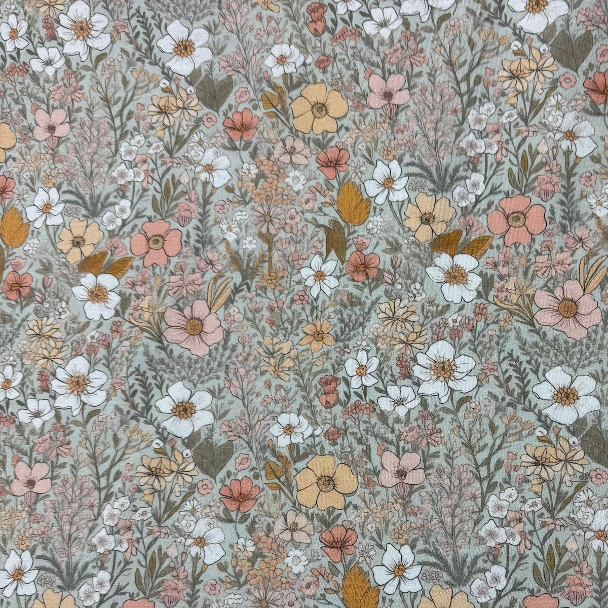 Nature's Fabrics floral print fabric with white, pink, and yellow wildflowers on soft green background