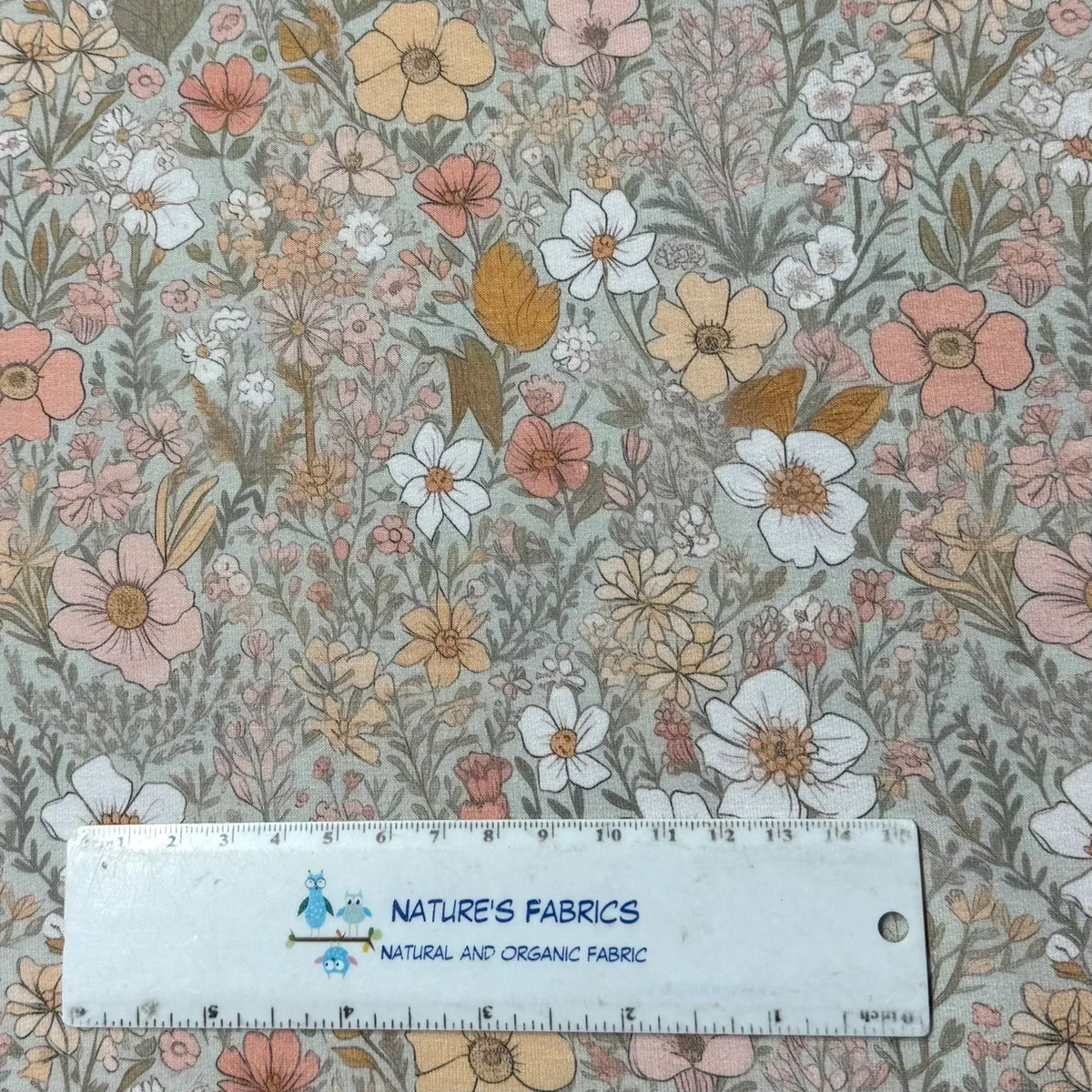 Nature's Fabrics floral print organic cotton fabric with pink, white, and yellow flowers, ruler for scale