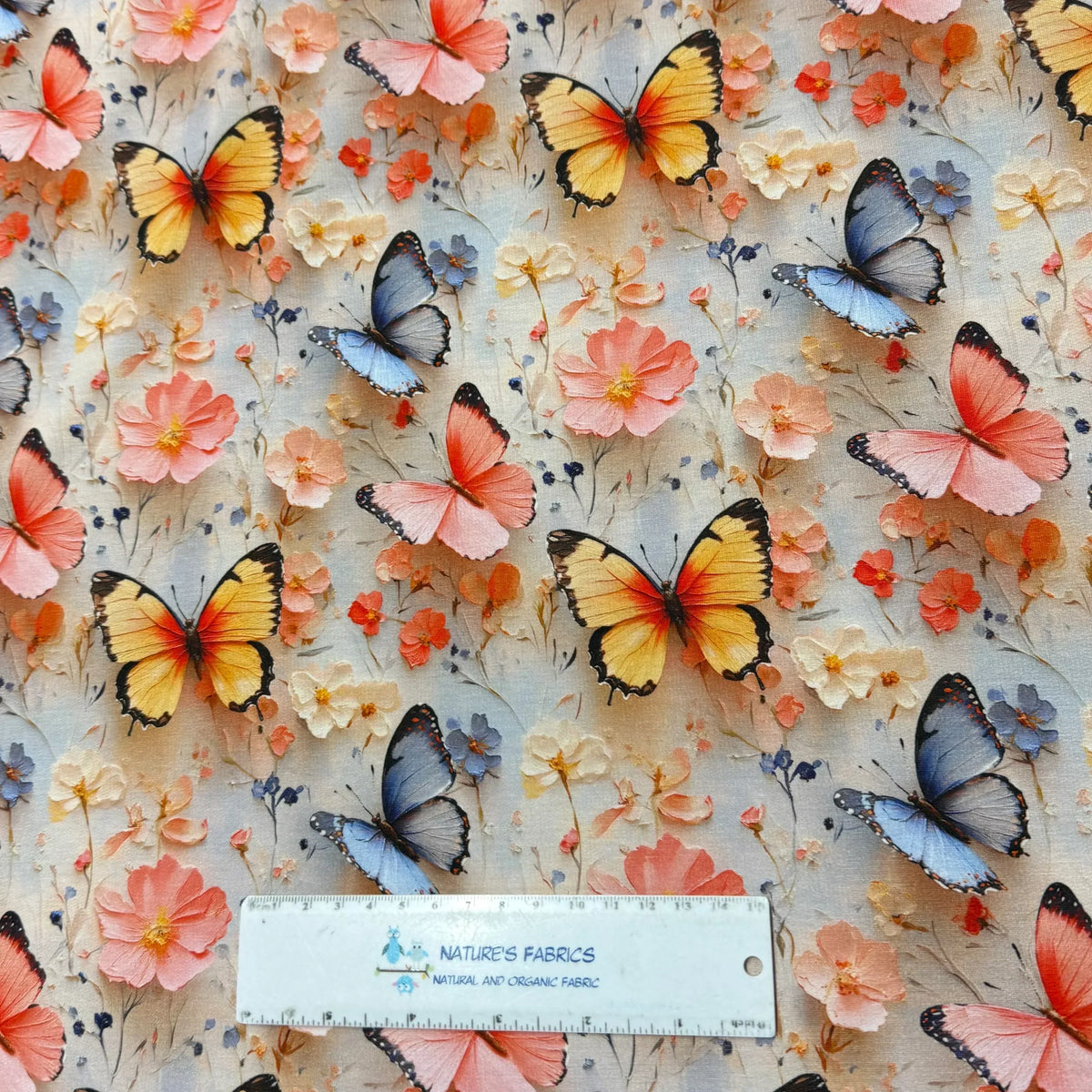 Nature's Fabrics butterfly and floral print fabric with pink, blue, and yellow butterflies on natural background