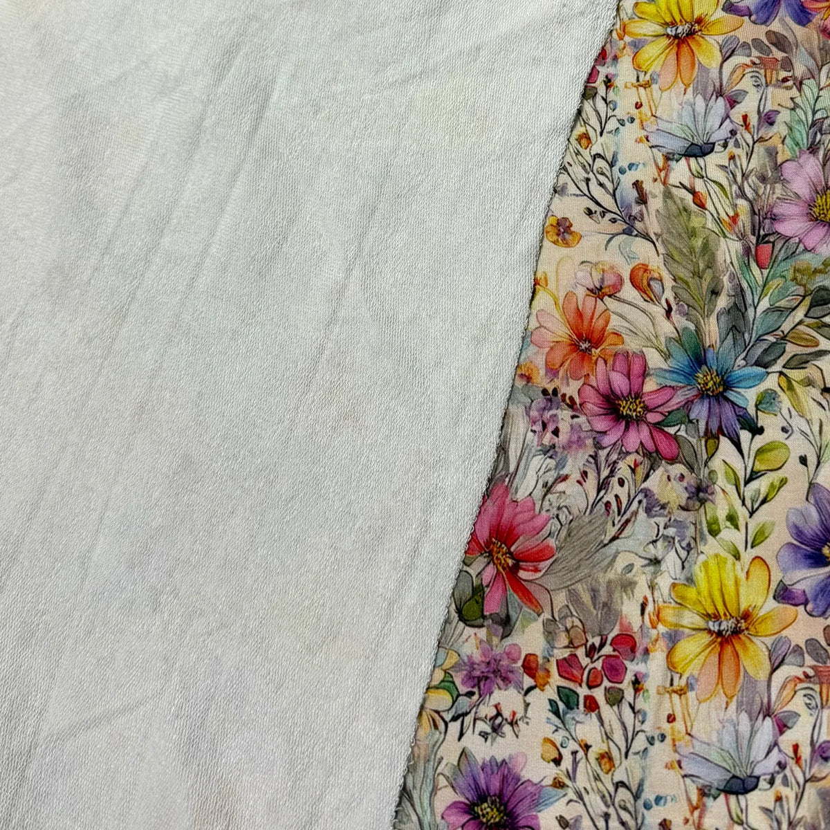 Nature's Fabrics floral print fabric featuring colorful wildflowers on a cream background.