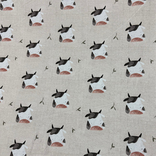 Cow print fabric by Nature's Fabrics, featuring cute cow faces on natural cotton