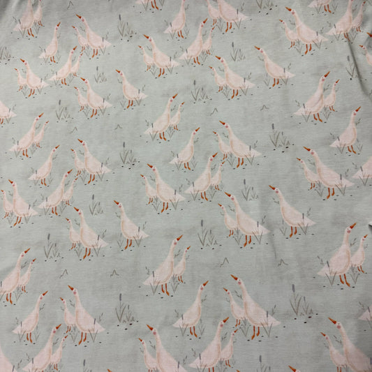 Nature's Fabrics organic cotton fabric with pink geese print on sage green background, eco-friendly textile