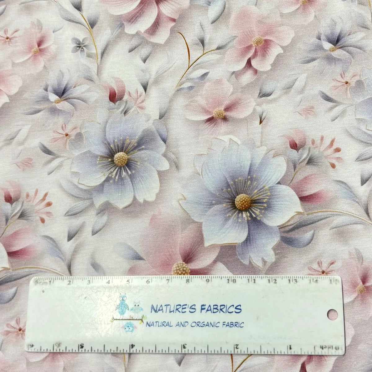 Nature's Fabrics floral print cotton fabric with soft pink and blue flowers, ruler for scale