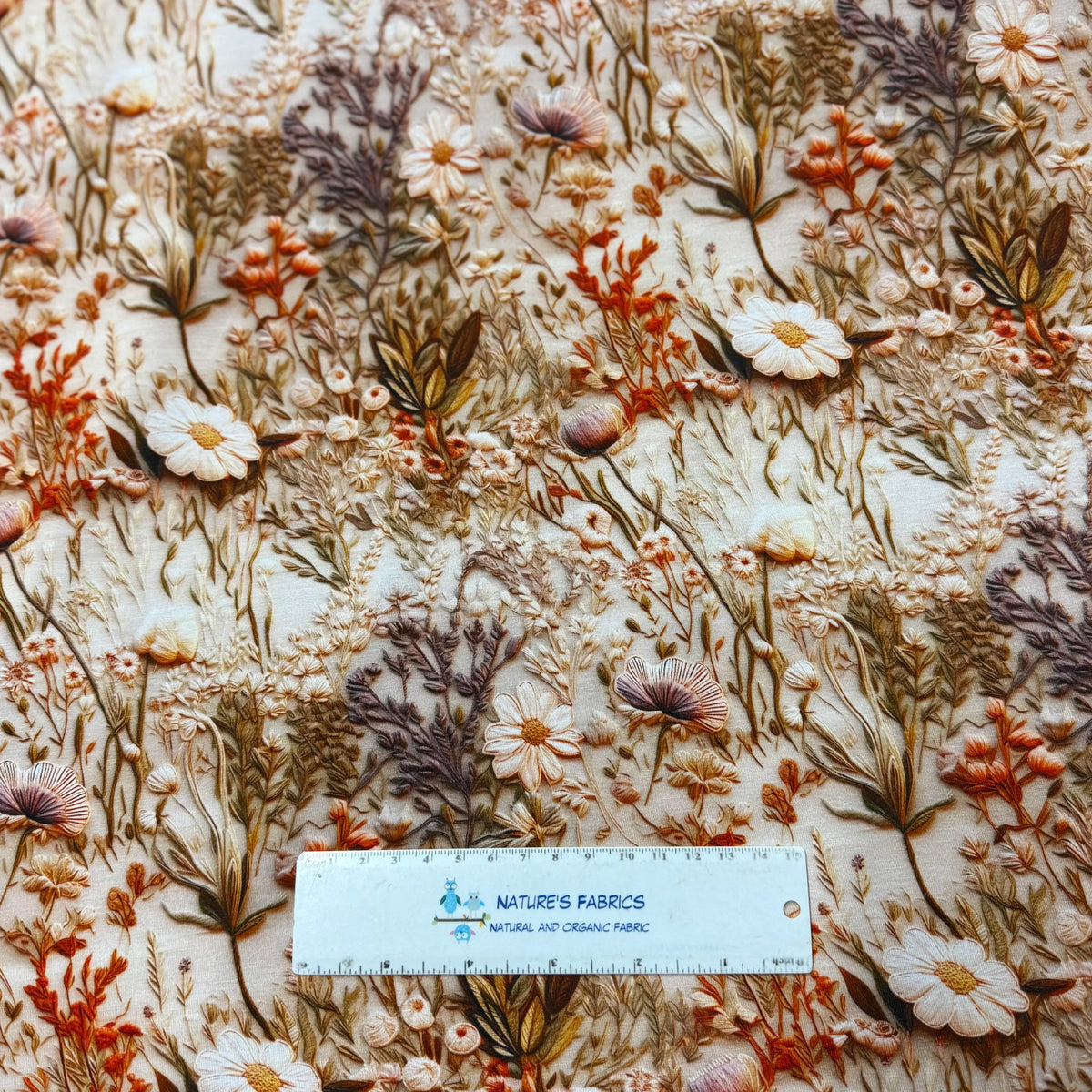 Nature's Fabrics textured floral embroidery fabric in earthy tones with measuring ruler