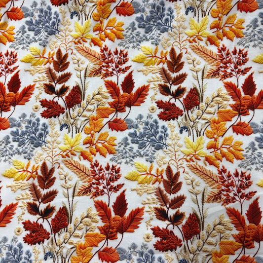 Nature's Fabrics embroidered cotton fabric featuring autumn leaves in orange, yellow, and grey.