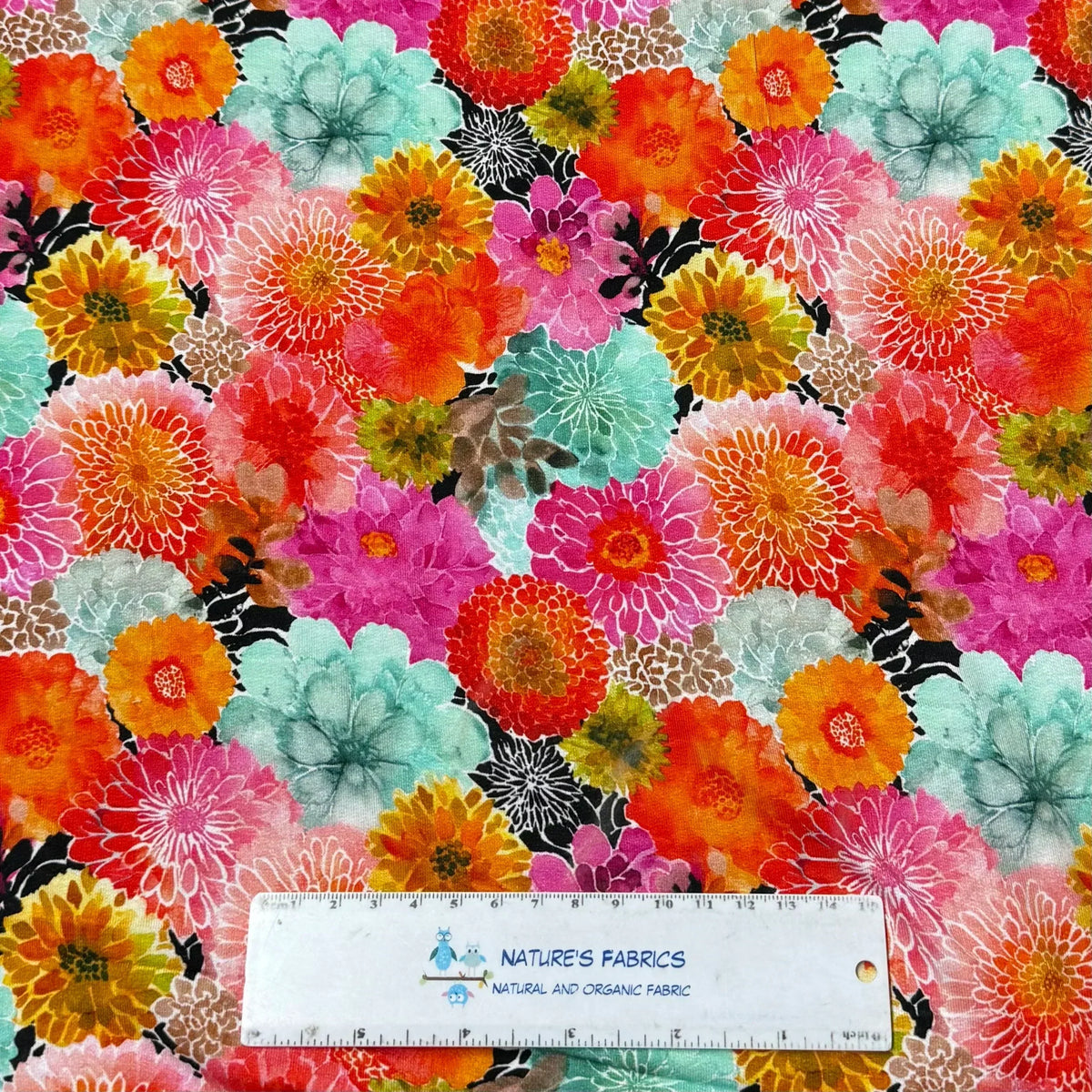 Colorful floral pattern organic fabric from Nature's Fabrics with a ruler for scale.