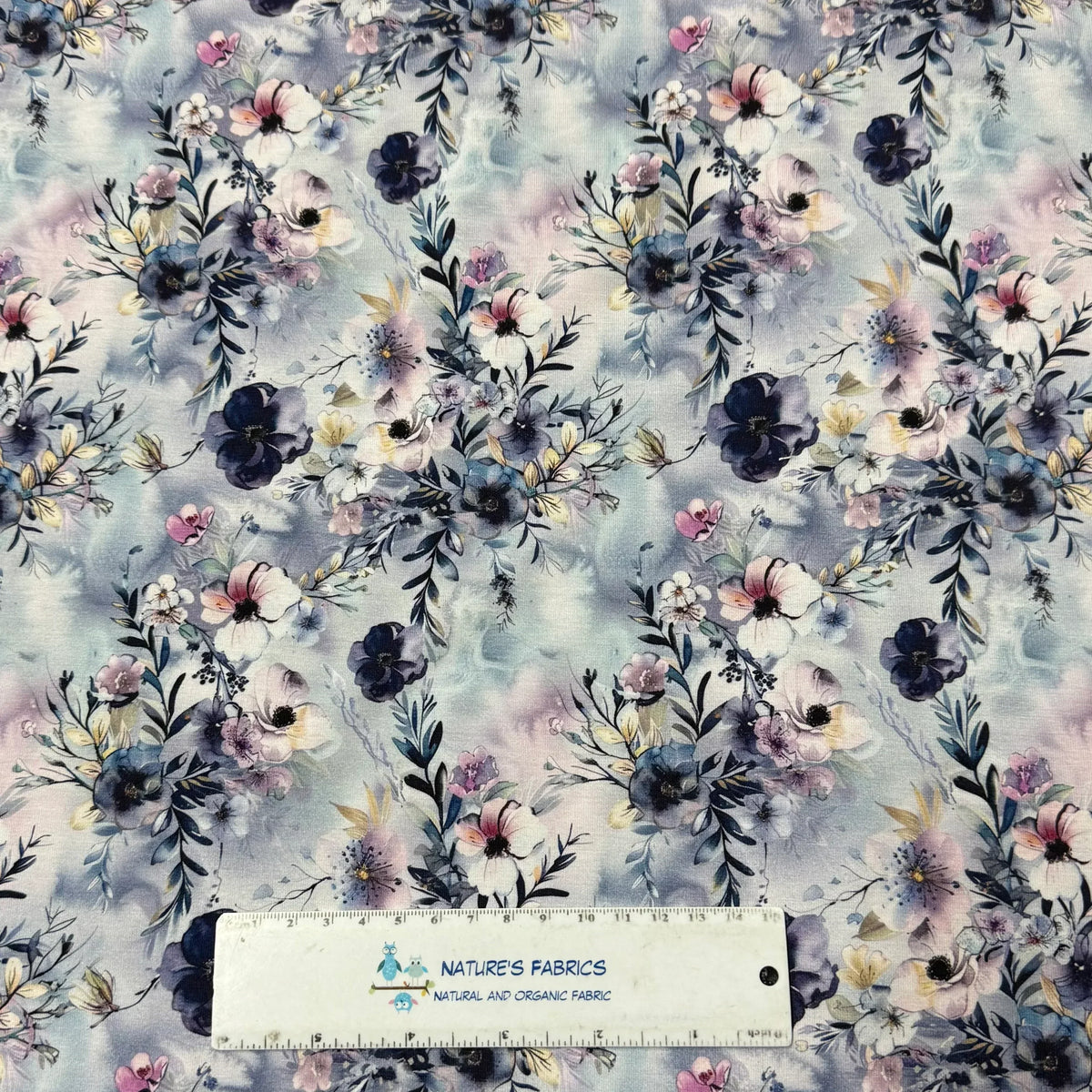 Nature's Fabrics floral print cotton fabric with blue, pink, and white flowers on soft watercolor background
