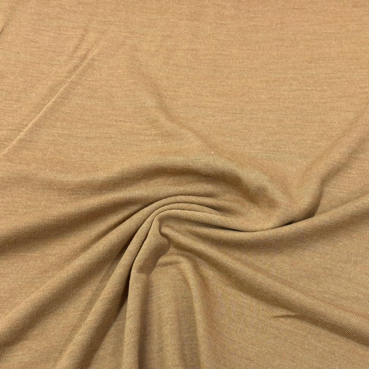 Tan organic cotton knit fabric by Nature's Fabrics, soft texture and natural drape for eco-friendly sewing projects