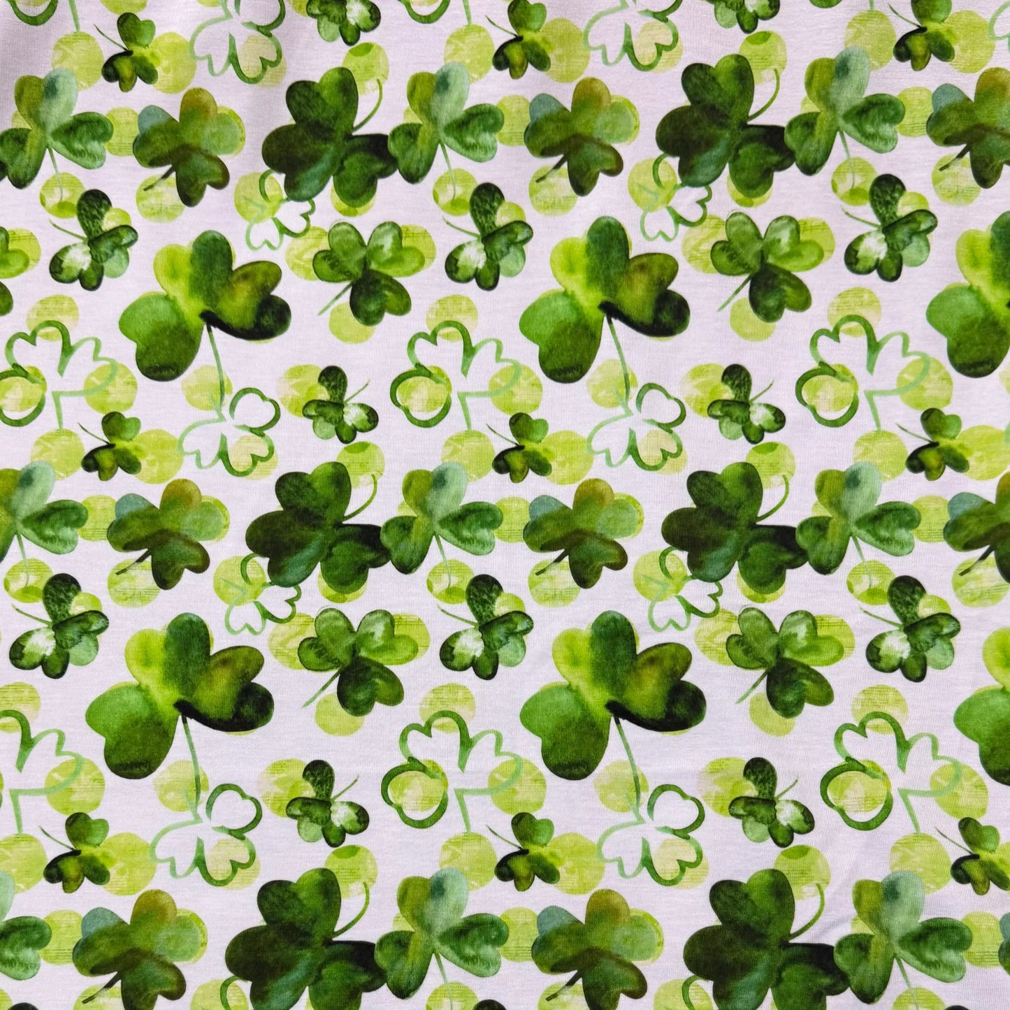 Green shamrock print fabric by Nature's Fabrics, ideal for St. Patrick's Day crafts and eco-friendly sewing projects.