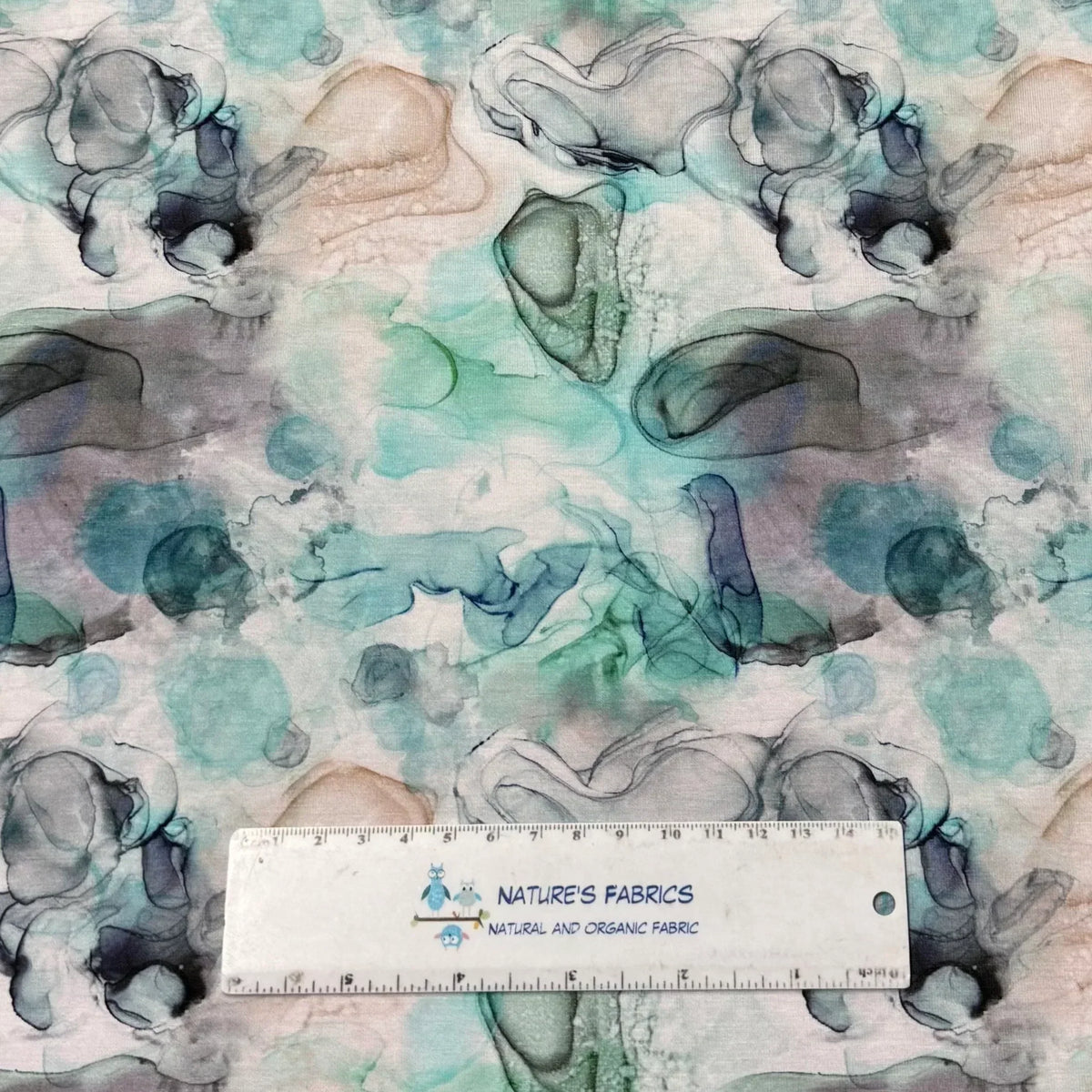 Nature's Fabrics organic fabric with abstract teal and grey watercolor patterns.