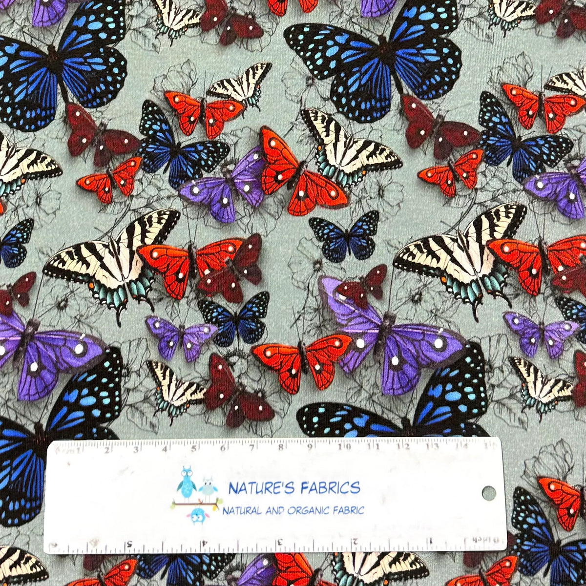 Nature's Fabrics butterfly print organic cotton fabric with colorful butterflies on gray background