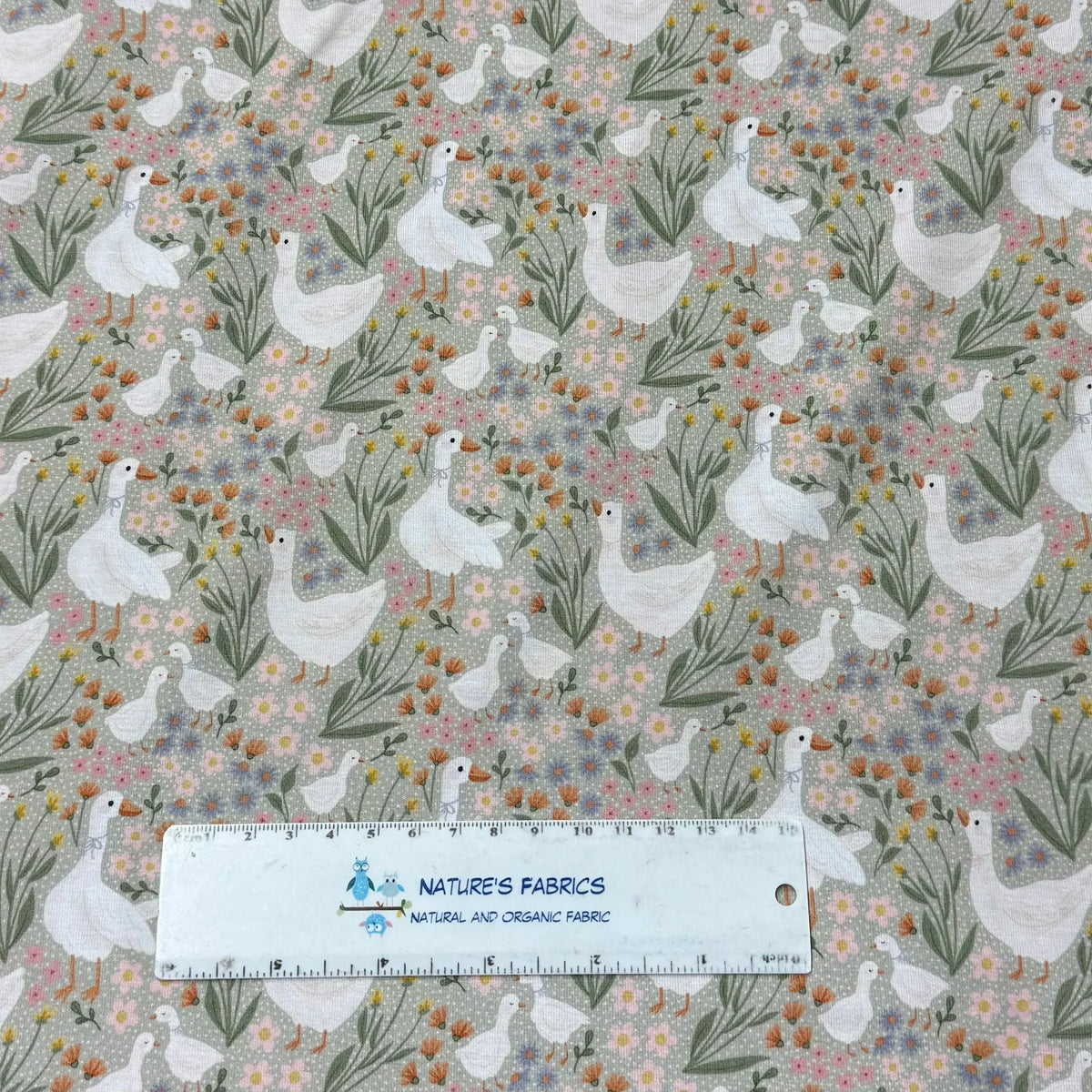 Nature's Fabrics organic cotton fabric with white geese and wildflowers pattern, ruler for scale