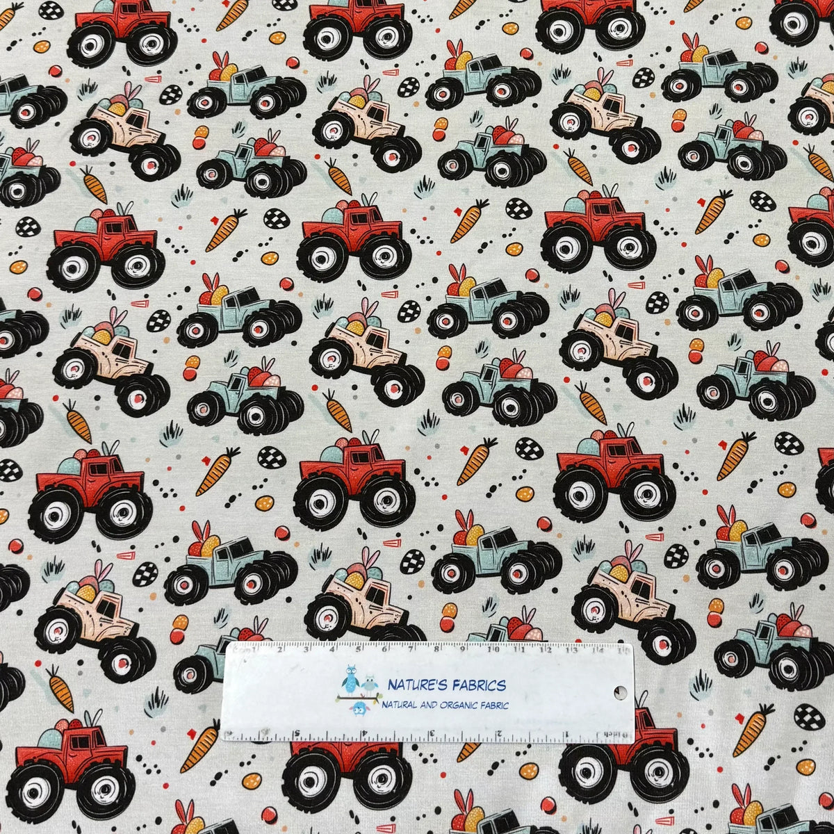 Nature's Fabrics Easter monster truck print fabric with bunnies, carrots, eggs on light gray background