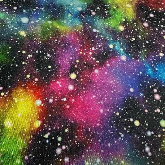 Colorful galaxy print fabric from Nature's Fabrics with vibrant nebula and star patterns.