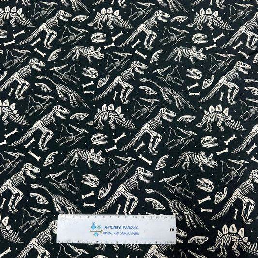 Nature's Fabrics black organic cotton fabric with white dinosaur skeleton pattern.
