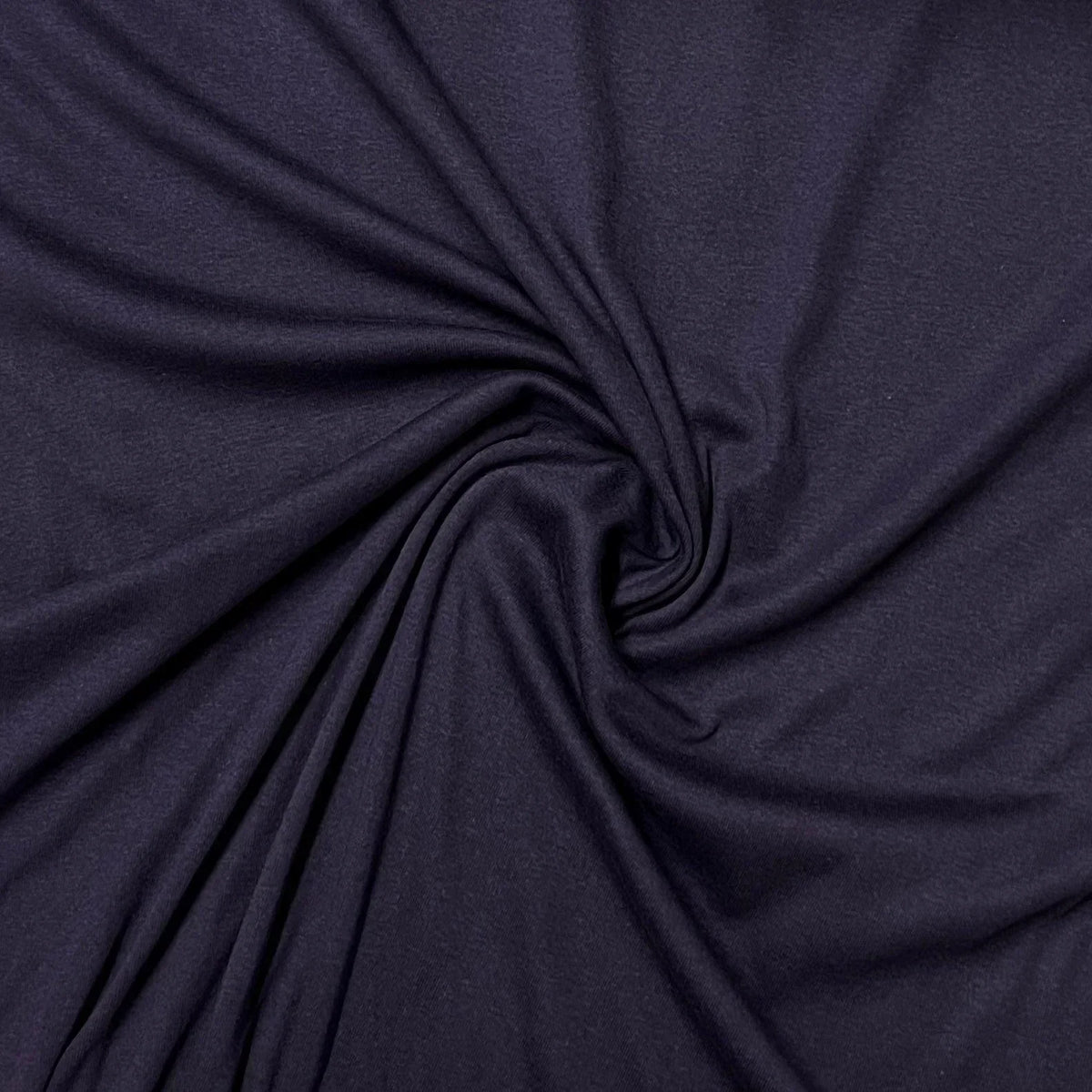 Deep purple premium natural fabric from Nature's Fabrics draped in a spiral pattern.