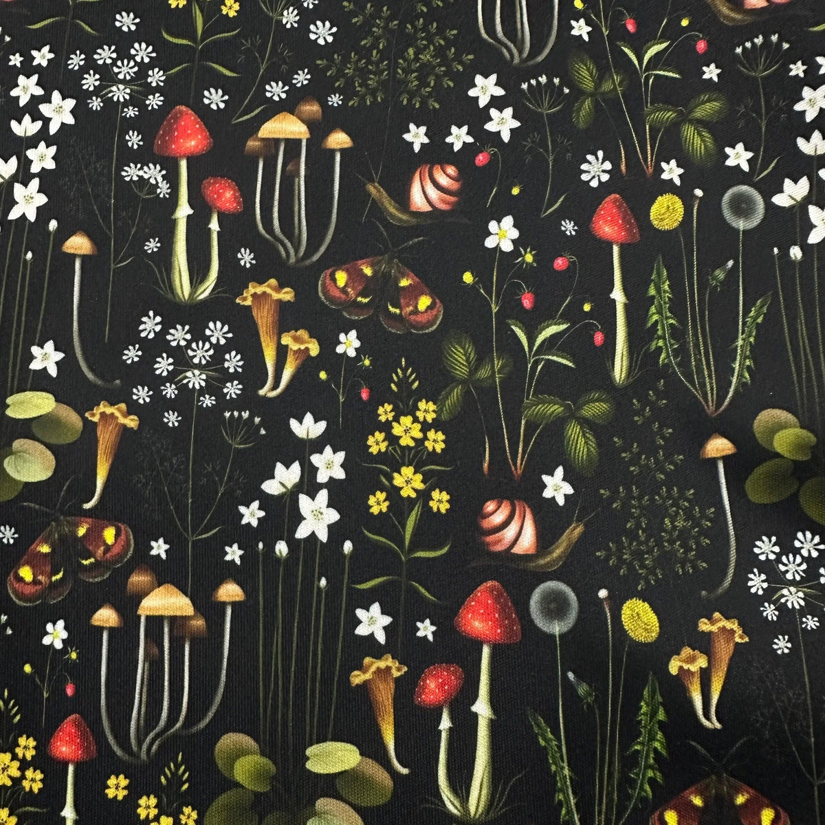 Nature's Fabrics botanical print fabric with mushrooms, snails, and wildflowers on black background