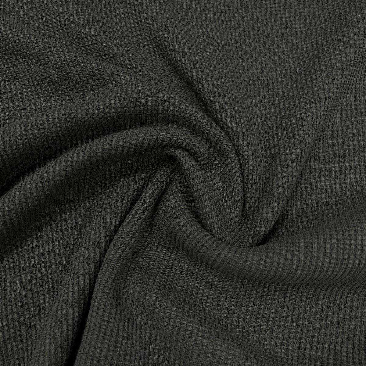 Close-up of dark grey ribbed knit fabric draped in swirls from Nature's Fabrics