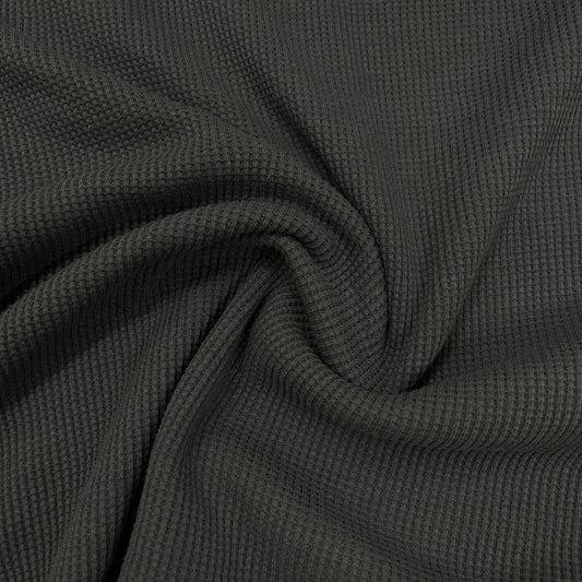 Close-up of dark grey ribbed knit fabric draped in swirls from Nature's Fabrics